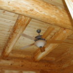 Ceiling fan between large log beams