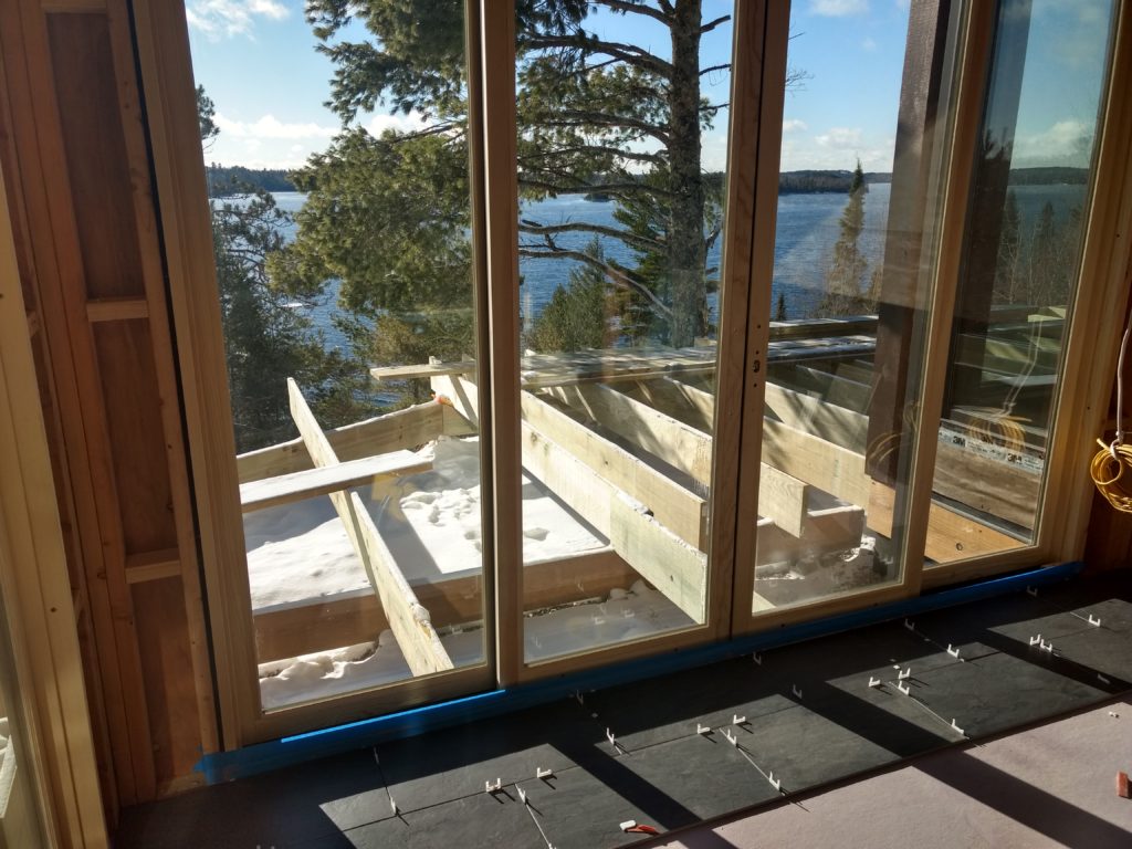 Tile starting in sunroom, and deck framing, view of the lake, Huisman Concepts custom home