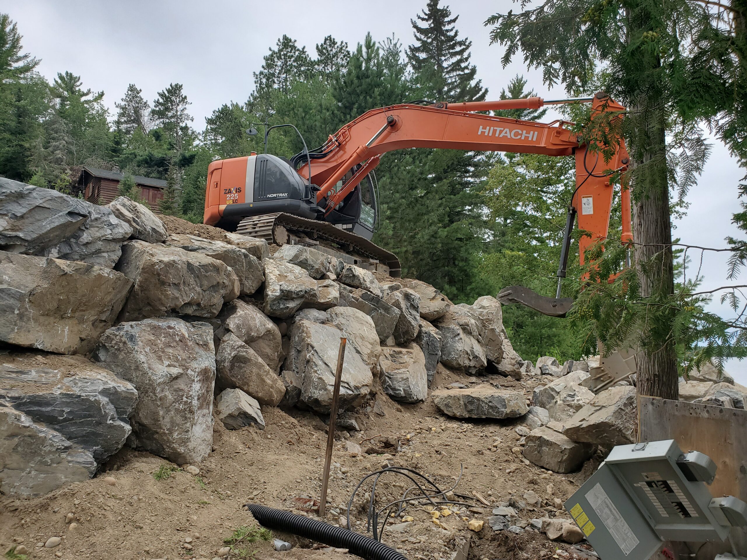 Retaining wall under way Retaining wall boulders, custom home by Huisman Concepts, Ely MN