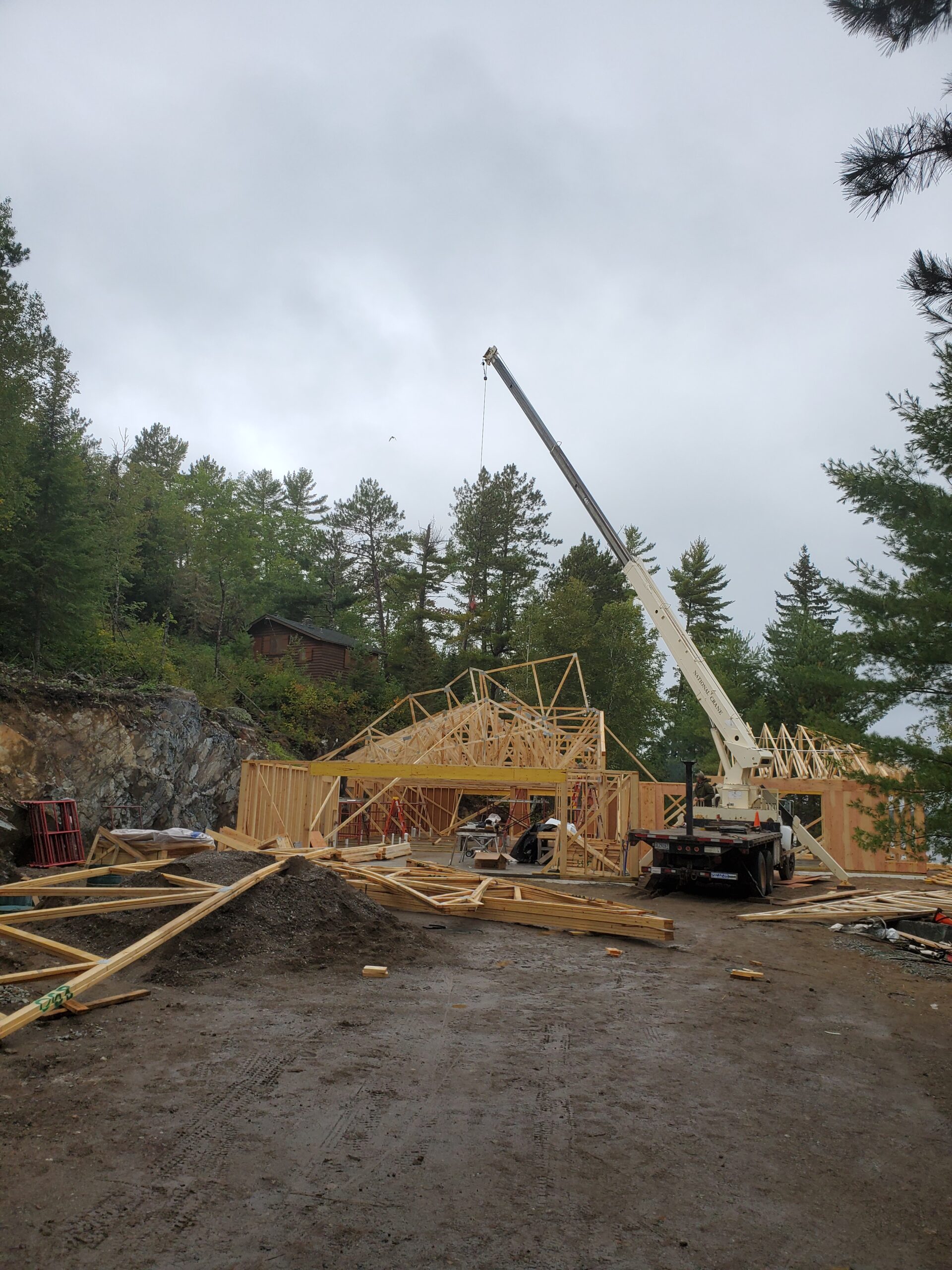 Crane setting trusses, custom home by Huisman Concepts