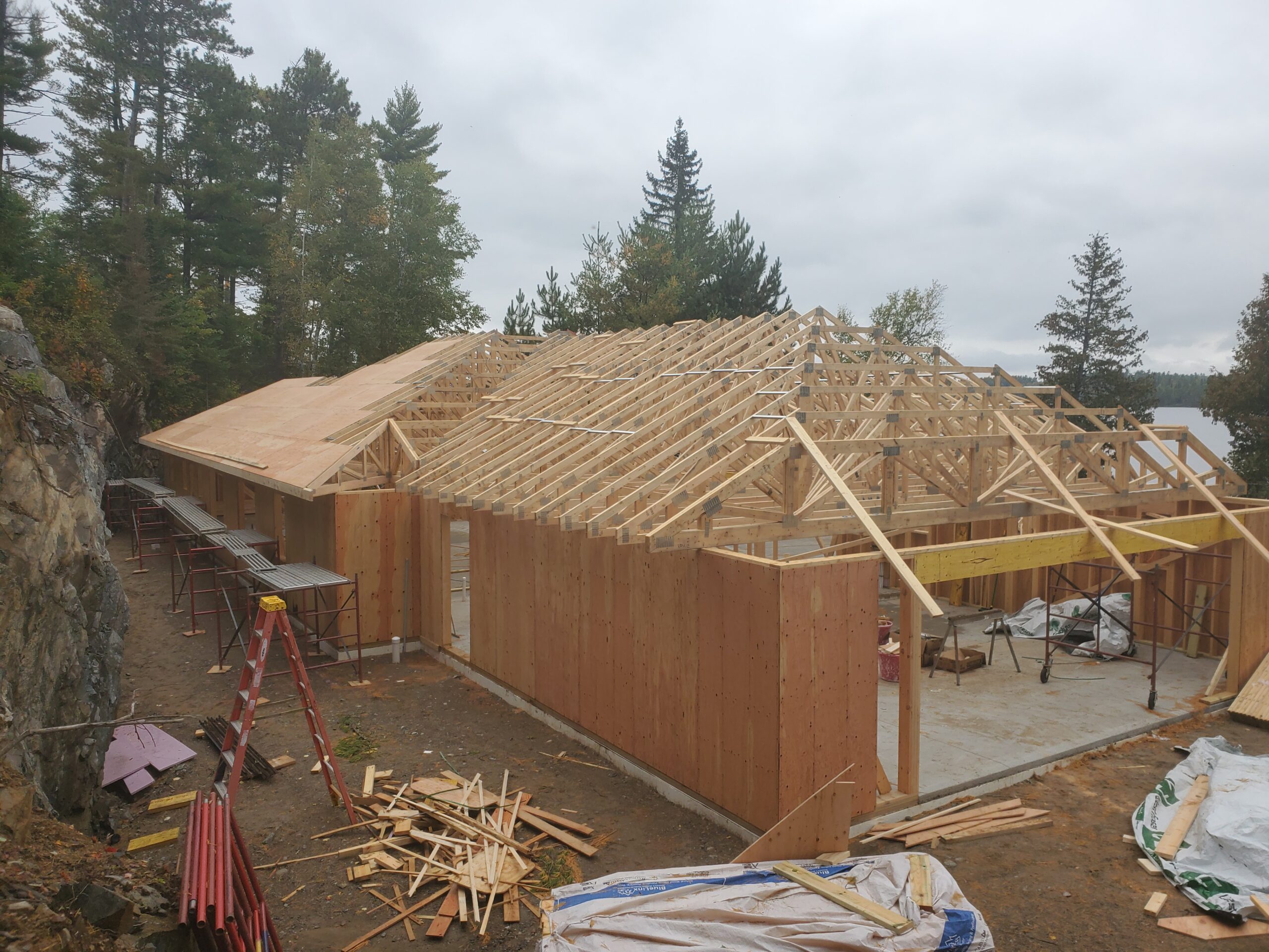 Trusses almost done, sheathing started, custom home Huisman Concepts