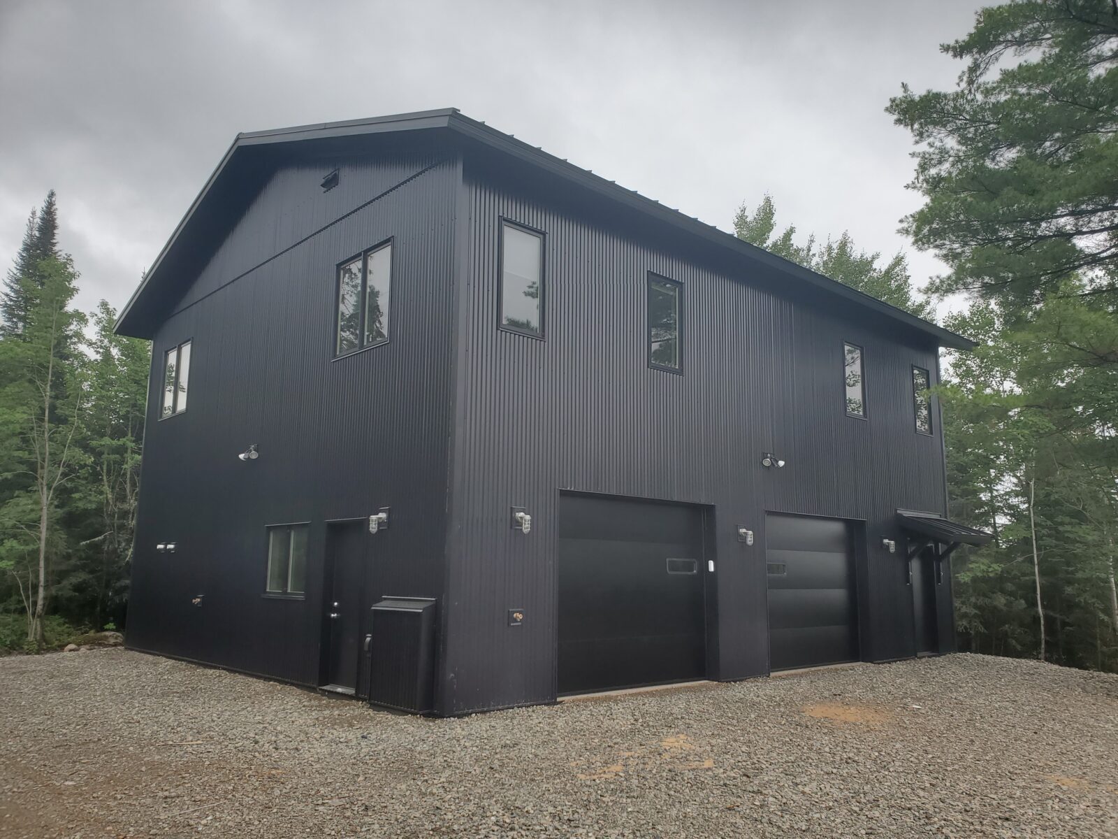 Large garage with steel siding and roof, shop below and living/studio space above